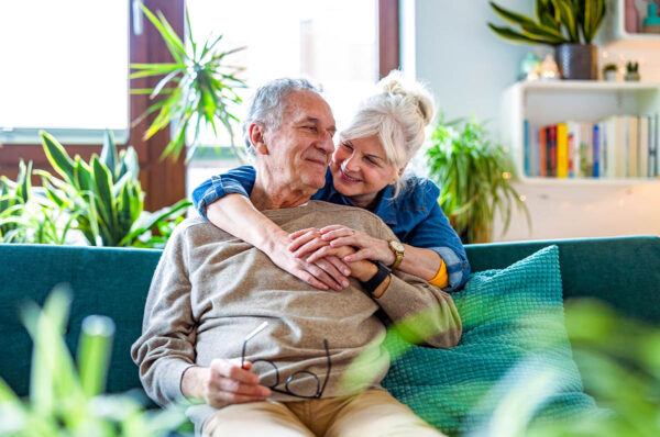 Woman hugging her husband from behind.
