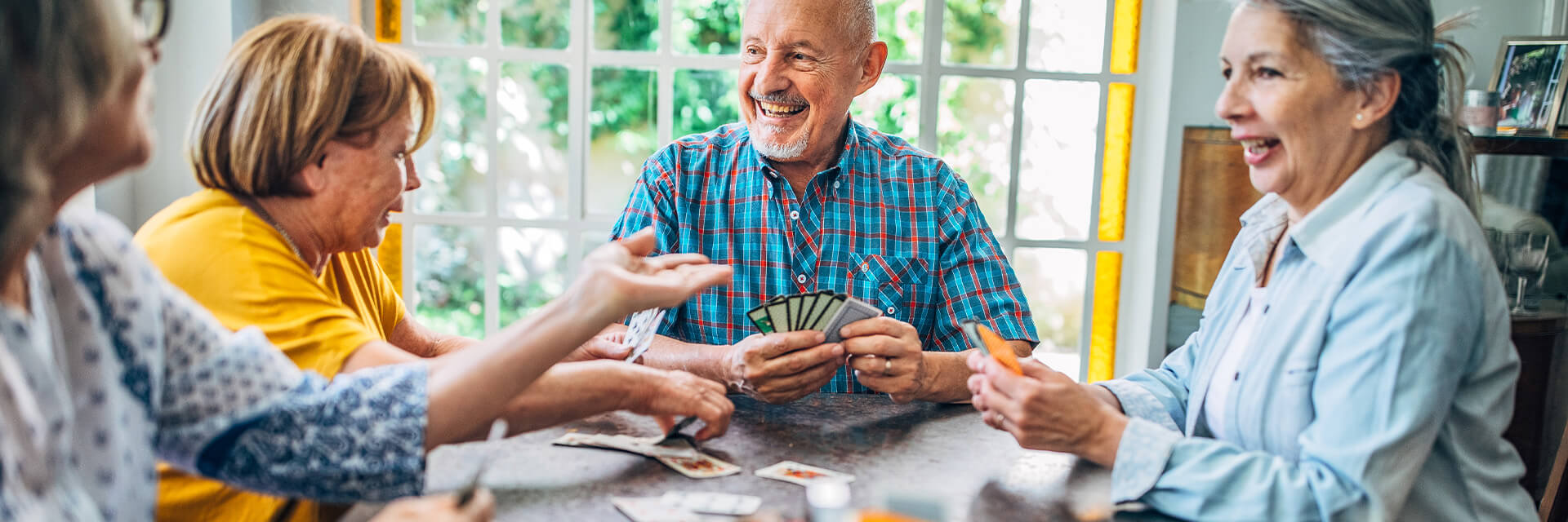 Group of senior adults playing a card game.